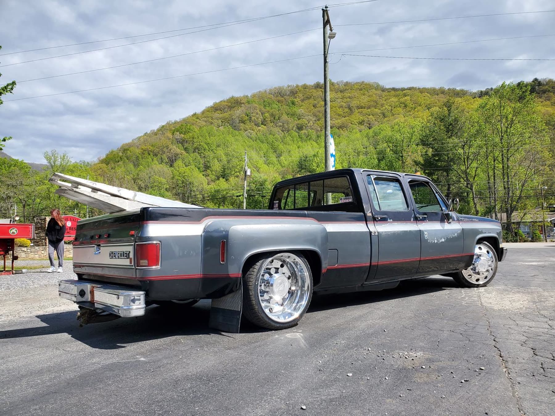 Silver lowered Chevy dually rear three-quarter view with polished wheels