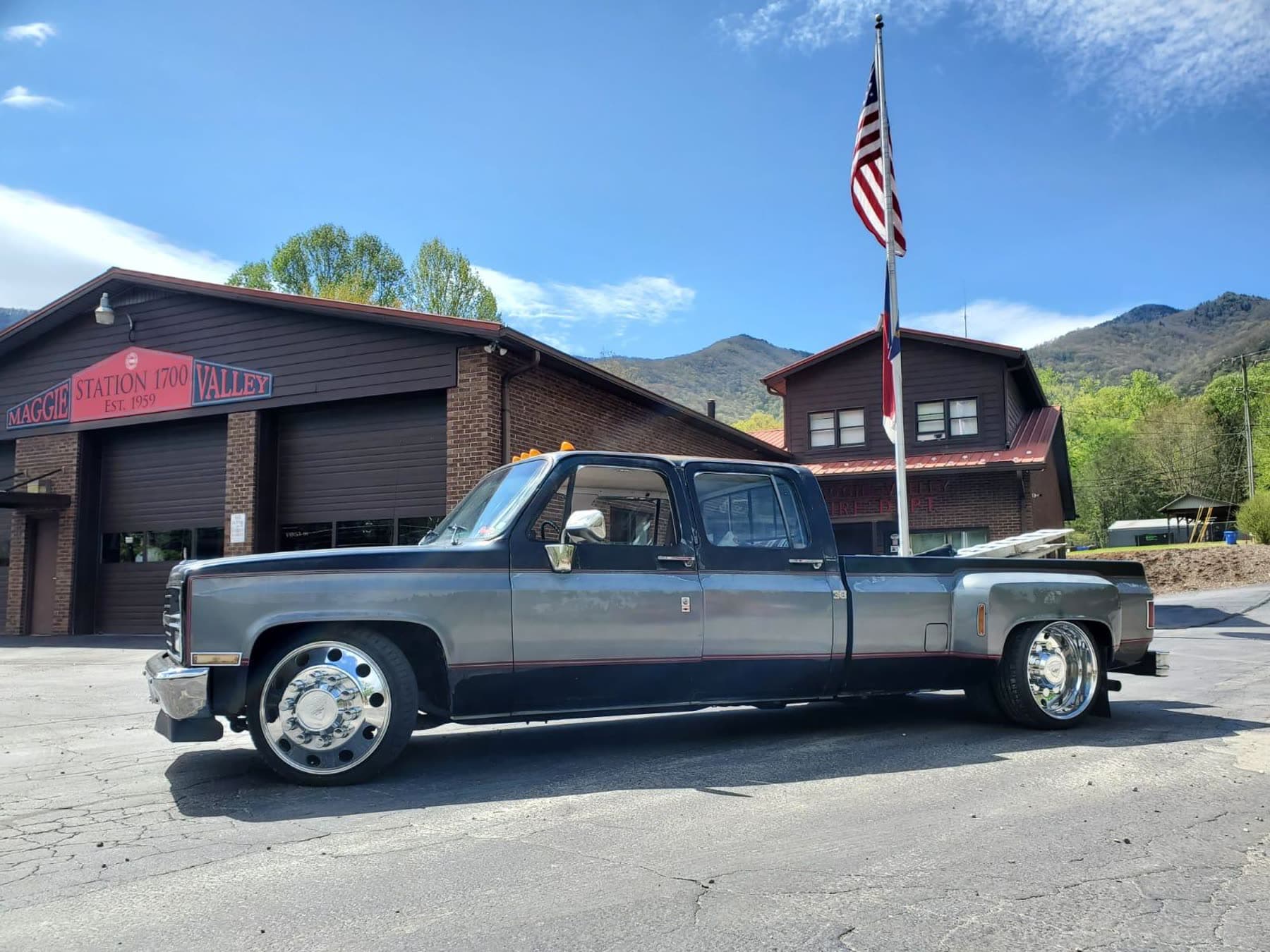 Silver lowered Chevy dually side profile with polished wheels
