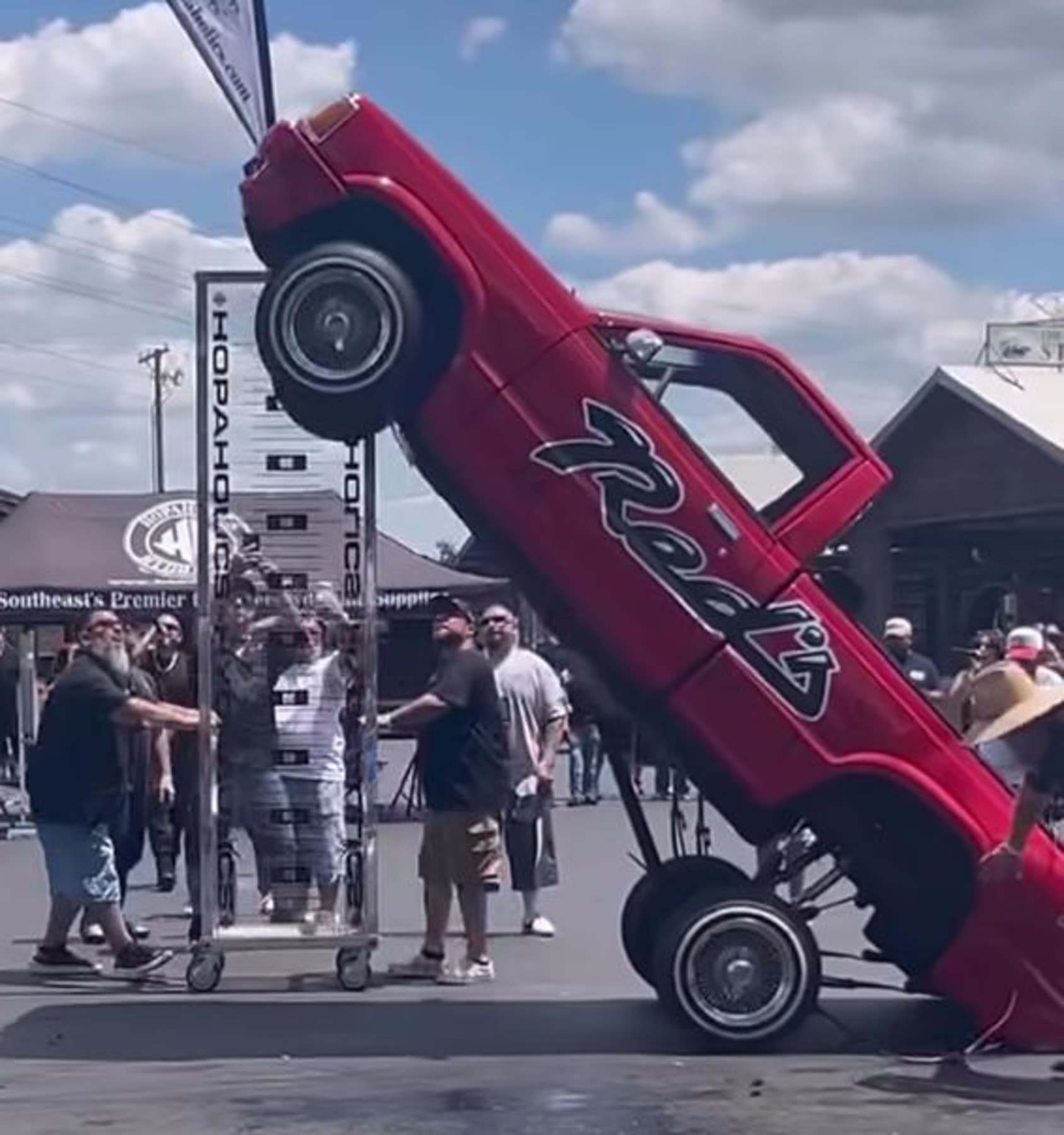 Red custom truck raised at an outdoor event