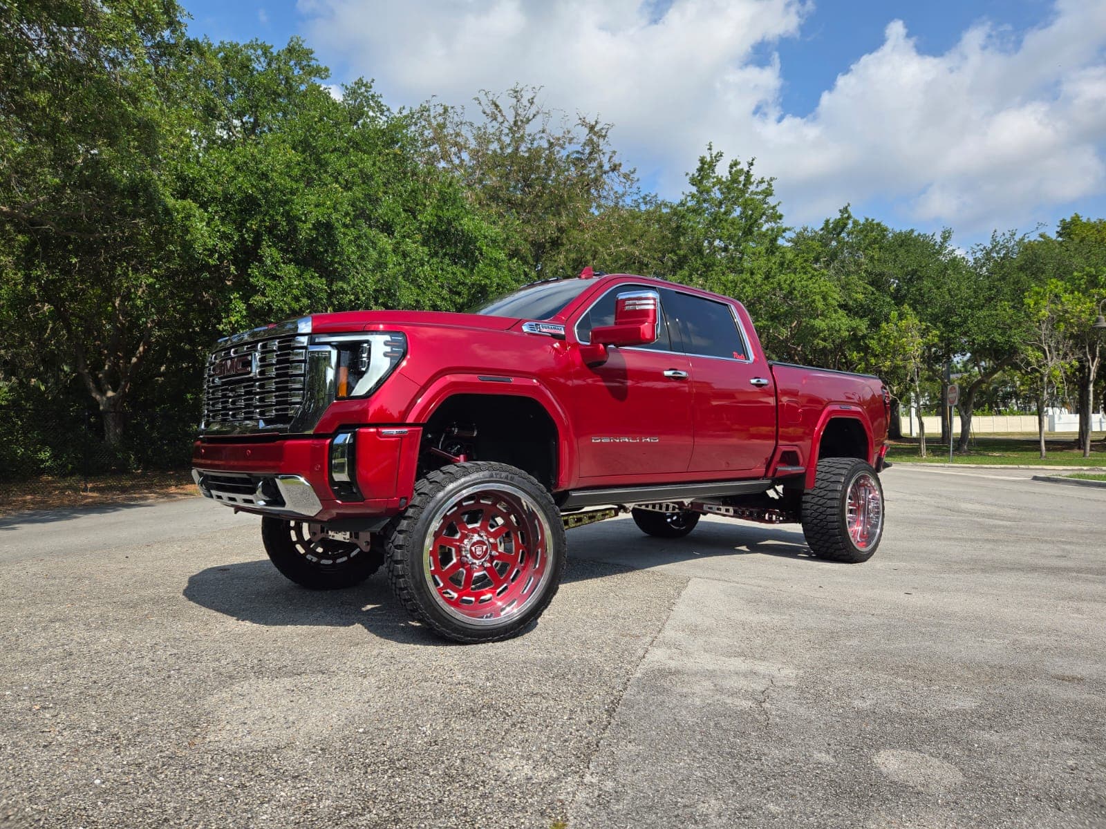 Lifted red GMC Denali on custom forged Diesel Wheels viewed from the front